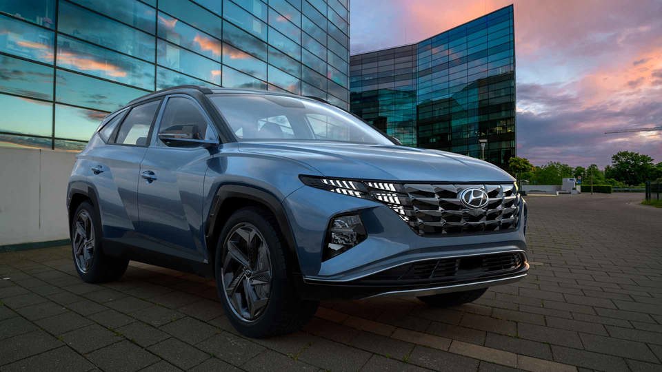 Blue Hyundai Tucson parked outside of glass building