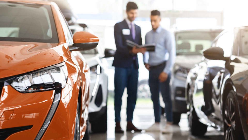 Man speaking to a sales person at a dealership