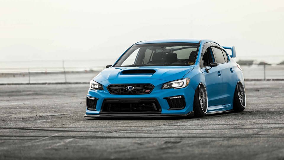 Blue Subaru WRX STI driving on racetrack