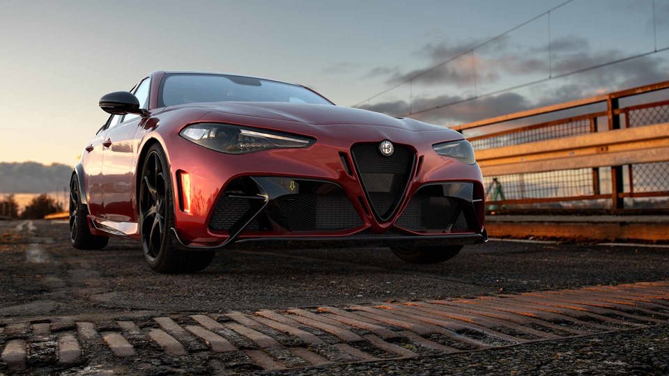 Red Alfa Romeo Giulia parked on a bridge