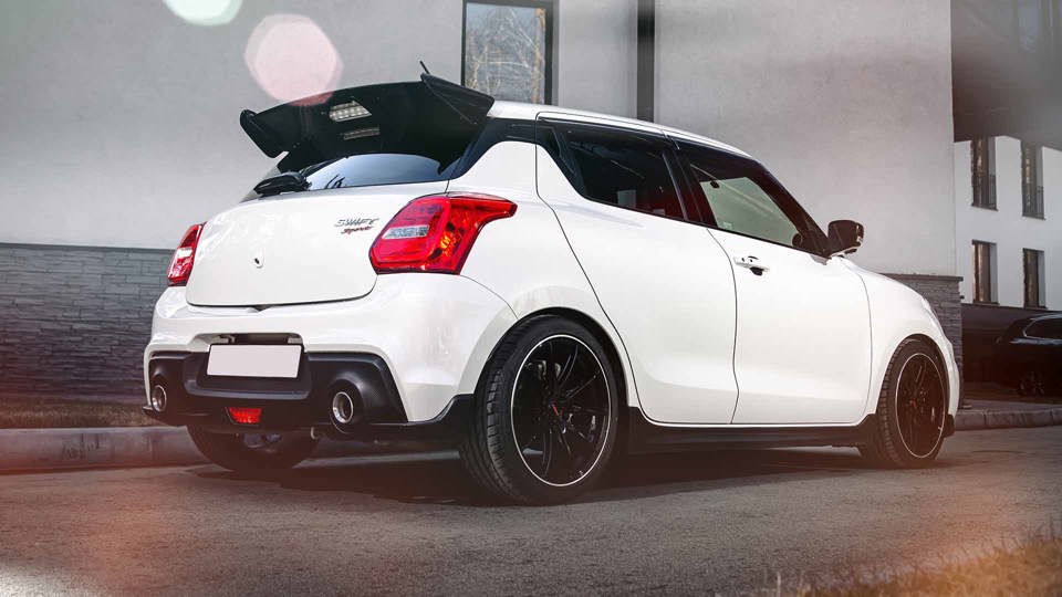 White Suzuki Swift Sport parked outside a white house
